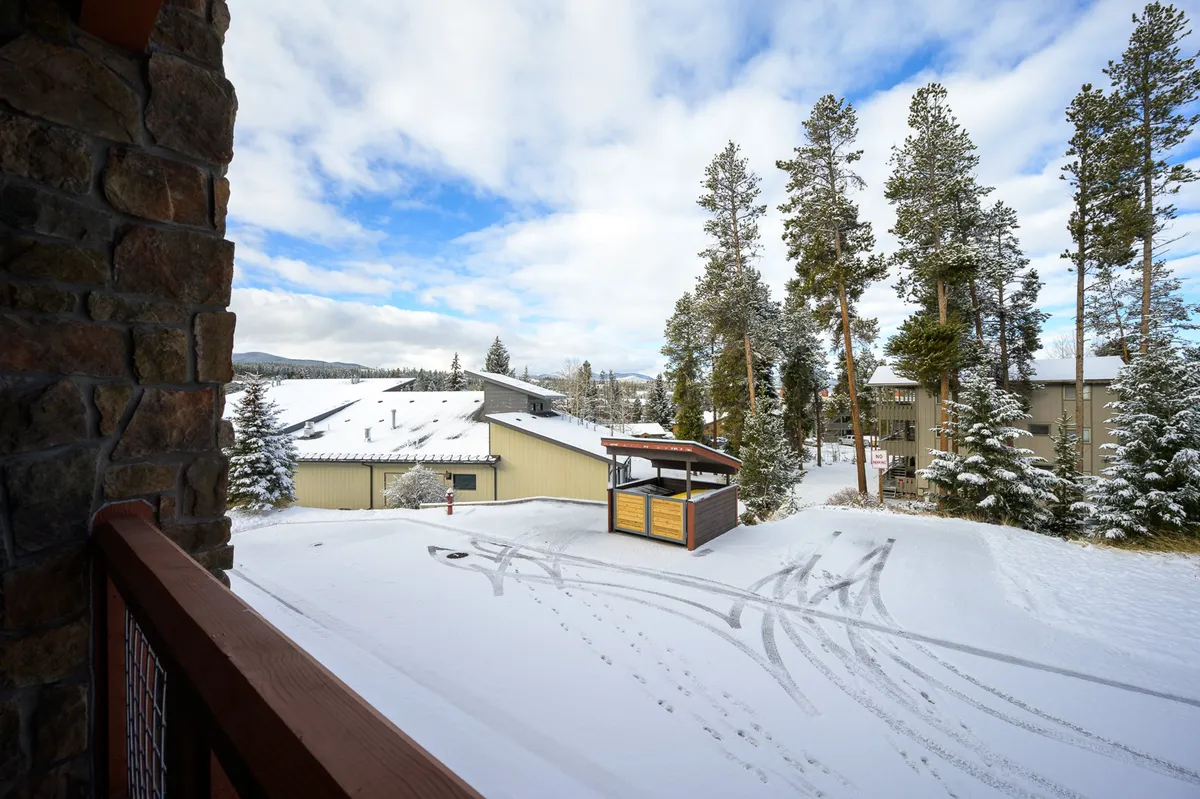 A snowy, scenic landscape featuring pine trees, snow-covered ground, buildings, and ski paths. The atmosphere evokes the winter adventure possibilities like skiing, snowboarding, and family fun in a picturesque setting.