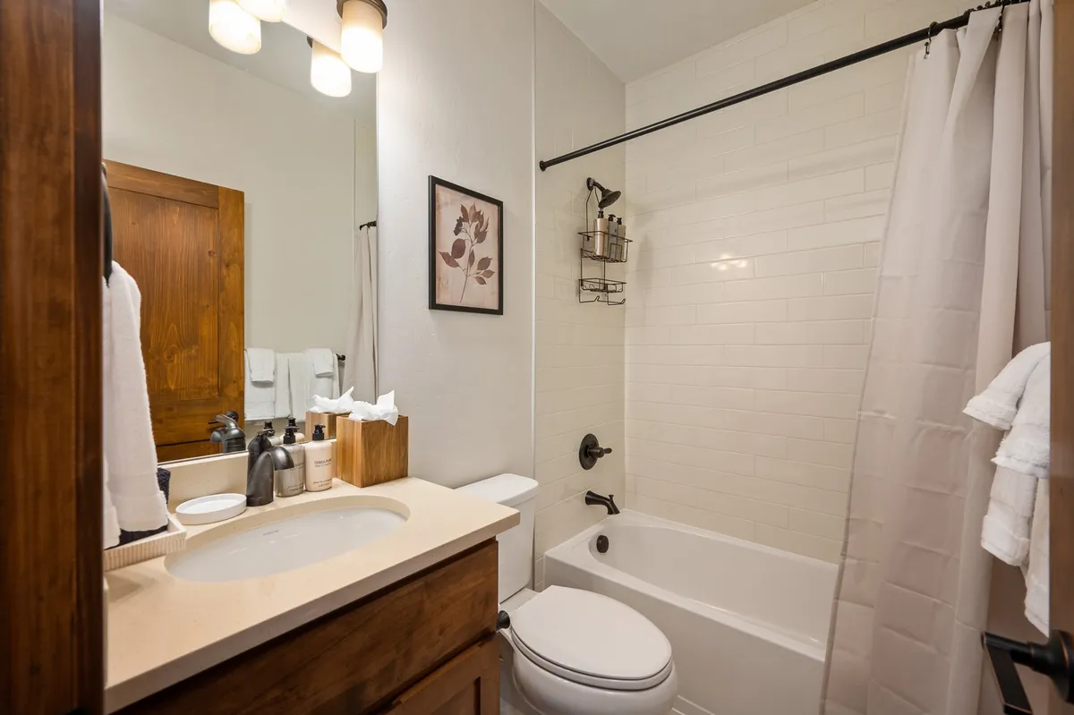A refreshing and serene bathroom interior, highlighting a vanity sink, bathtub, and decorative wall art. The space is designed for relaxation and features elements that evoke a spa-like experience.